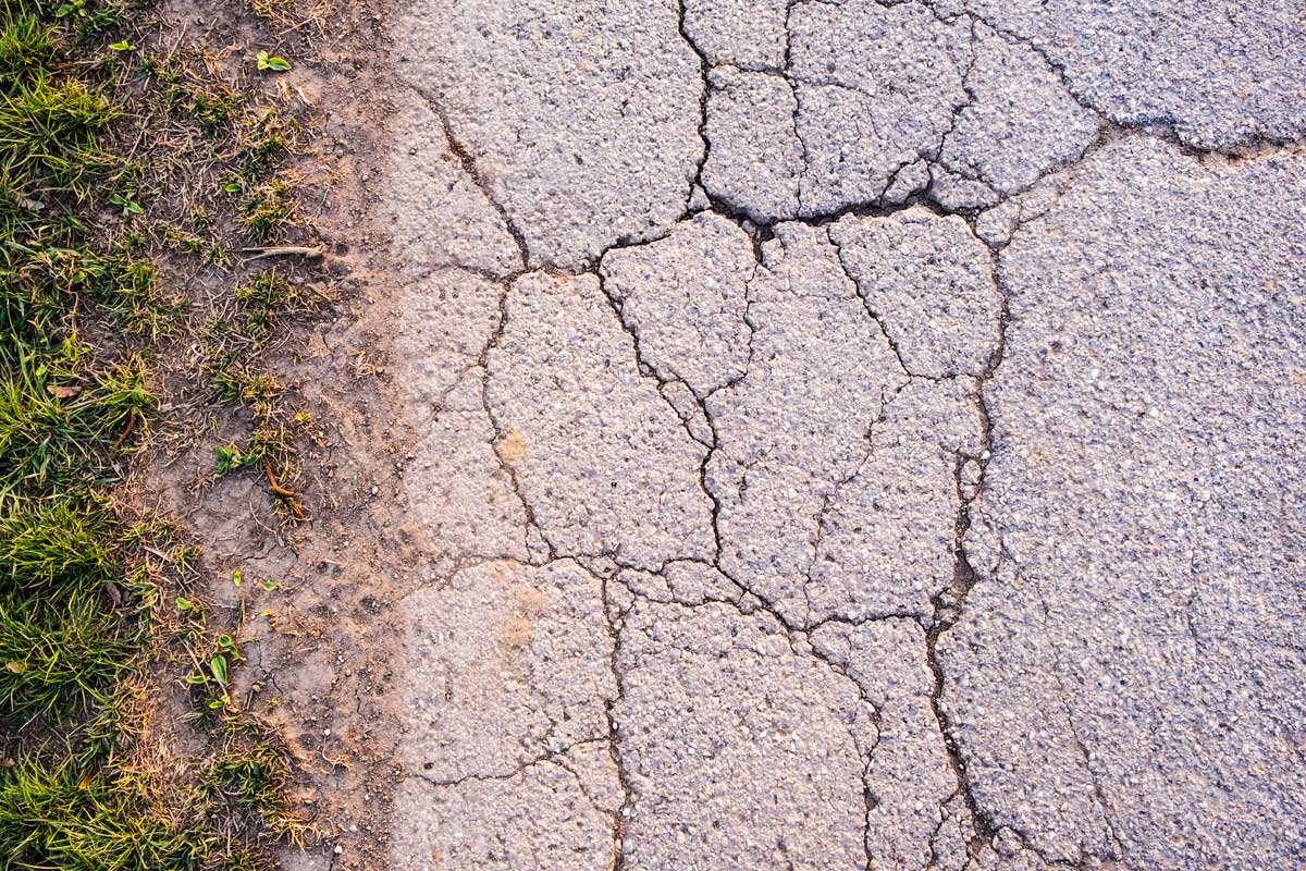 Moisture Intrusion: How Water Weakens Asphalt and Concrete from the Inside Out